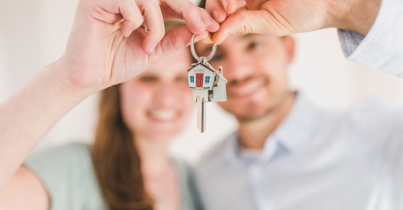 Ownership - Happy Couple Holding and Showing a House Key