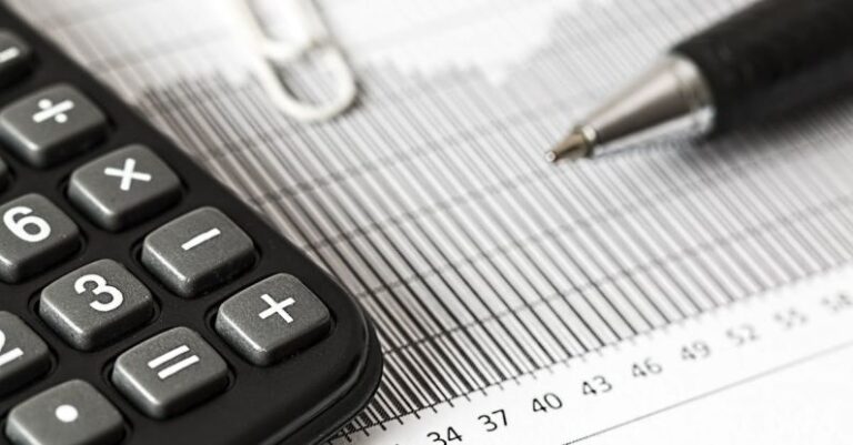 Taxes - Calculator and Pen on Table