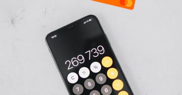 Expenses - A Mobile Phone with Calculator on a White Surface