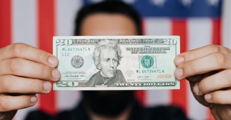 Debt - Unrecognizable man showing 20 American dollars